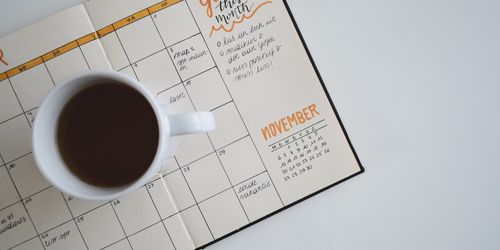 Coffee mug sitting on top of calendar