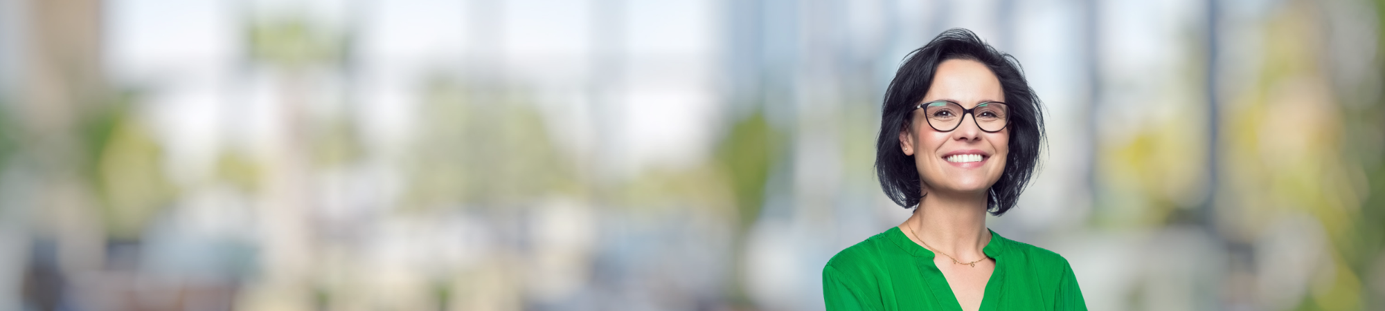 Female professional wearing green top and glasses.