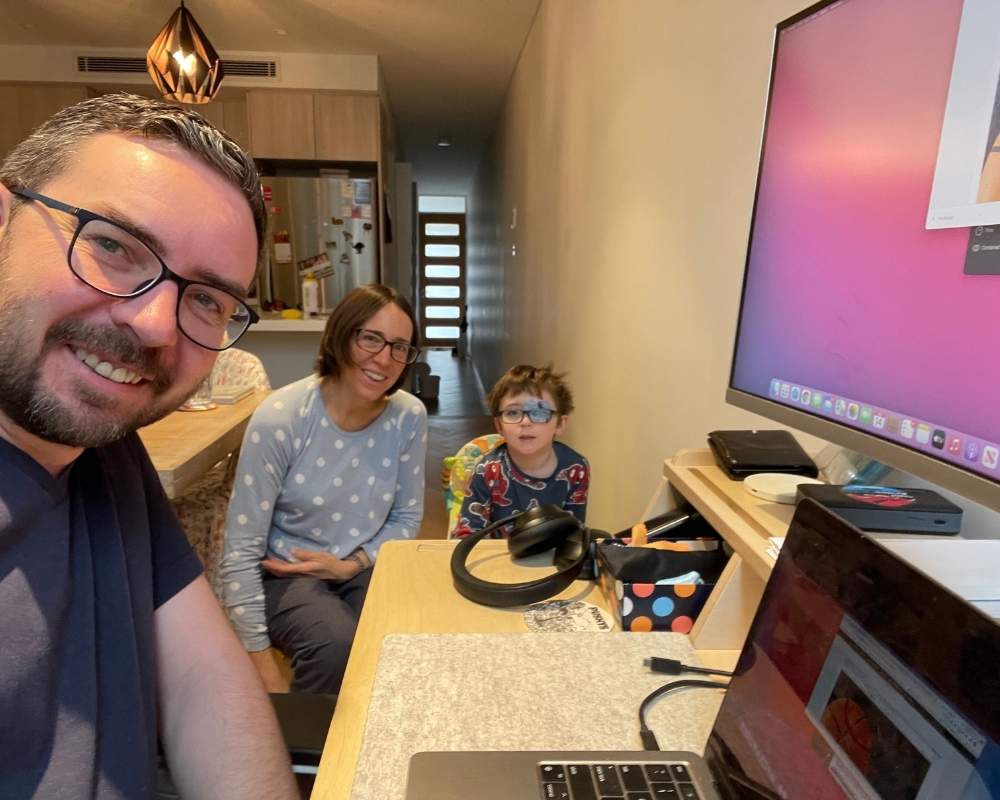 Man sitting at the computer with wife and son.