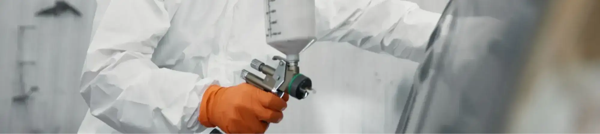 Vehicle spray painter applying paint in an Australian automotive workshop