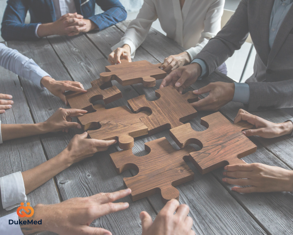 Multiple hands assembling a wooden puzzle, representing teamwork and strategic workforce planning