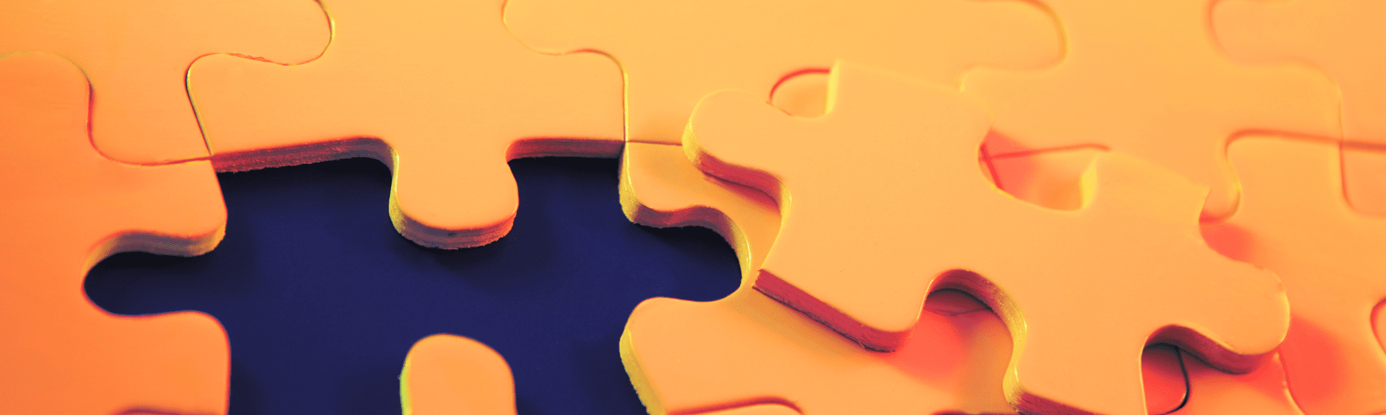 An orange jigsaw puzzle missing a piece 
