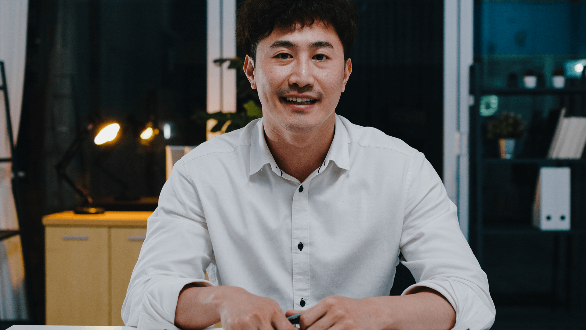 Confident professional sitting at a desk in a modern office environment, ready for a productive work session.