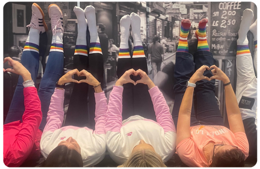 people with rainbow socks on posing with hand hearts