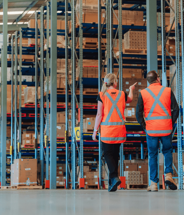 Two employees walking in a warehouse