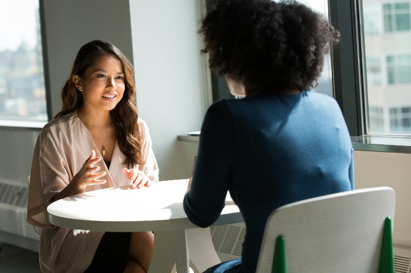 two female colleagues having open conversation in an office