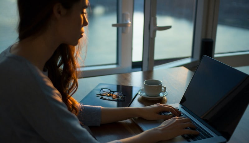 Woman Sending Email on Laptop at Desk