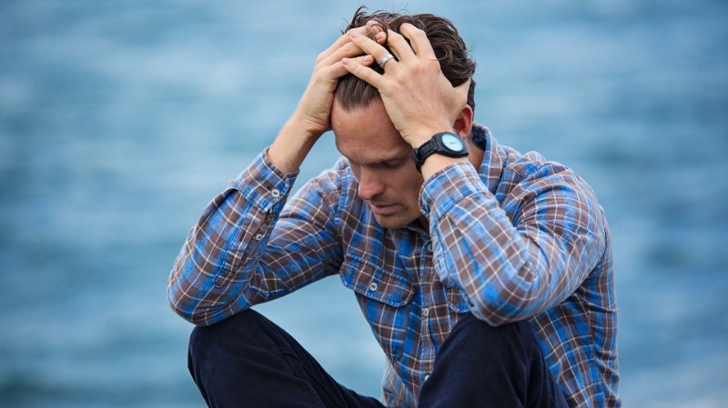 Blue Collar Worker Holding Head and Looking Visibly Stressed