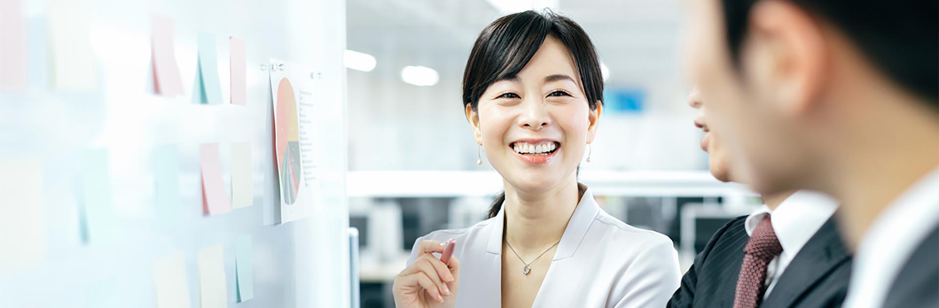 Japanese business woman smiling with her co workers