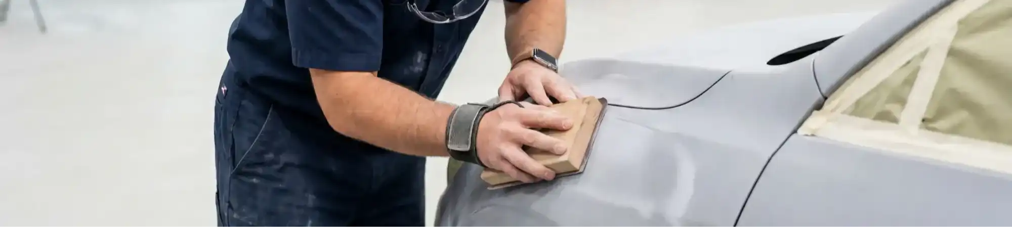 Collision repair specialist realigning a vehicle body after accident damage