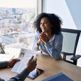 Applicant at an interview while interviewer looks at her resume 