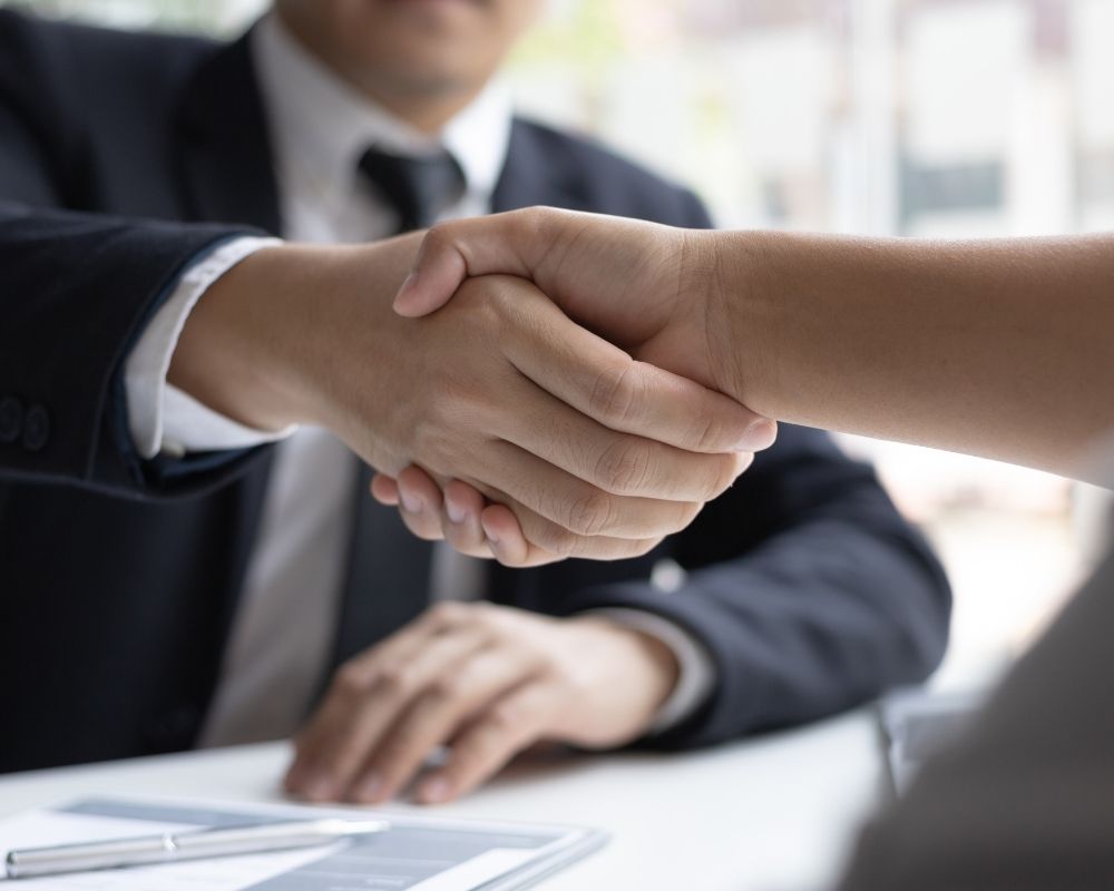 hiring manager shaking hands with hired candidate