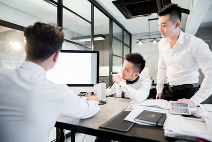 3 businessman looking at a monitor.