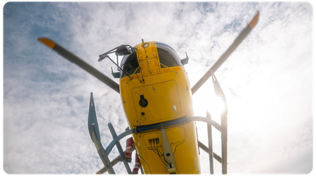 view from underneath a yellow helicopter in the sky