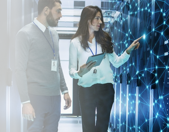 Two people working in a computer server room. 