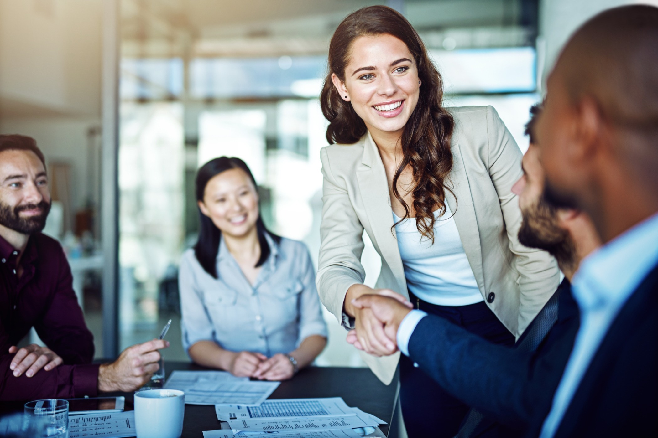 Person in a boardroom meeting smiling at people.