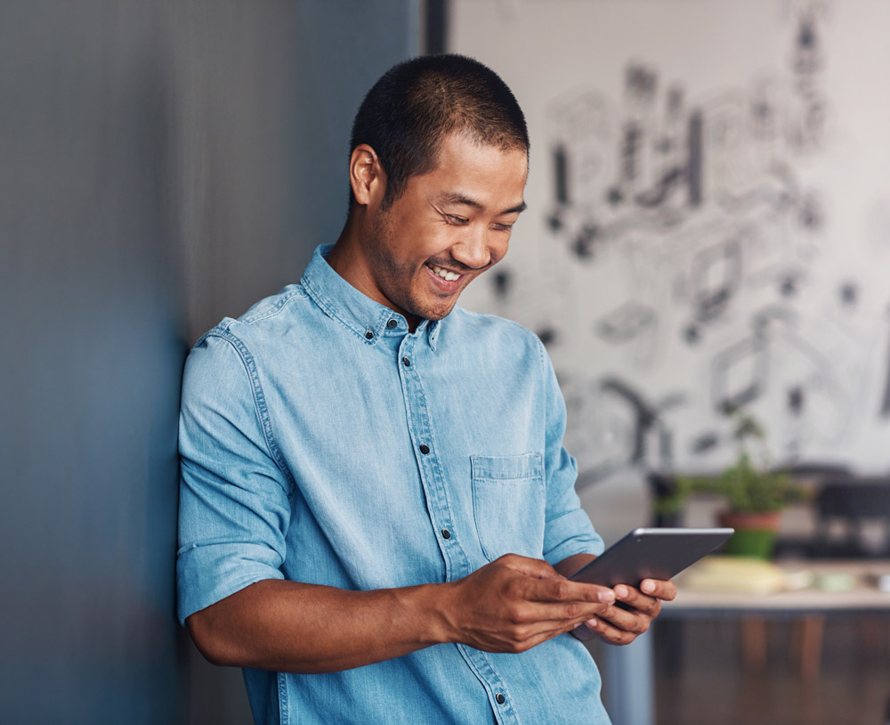 Happy Similling Man Reading Tablet Office