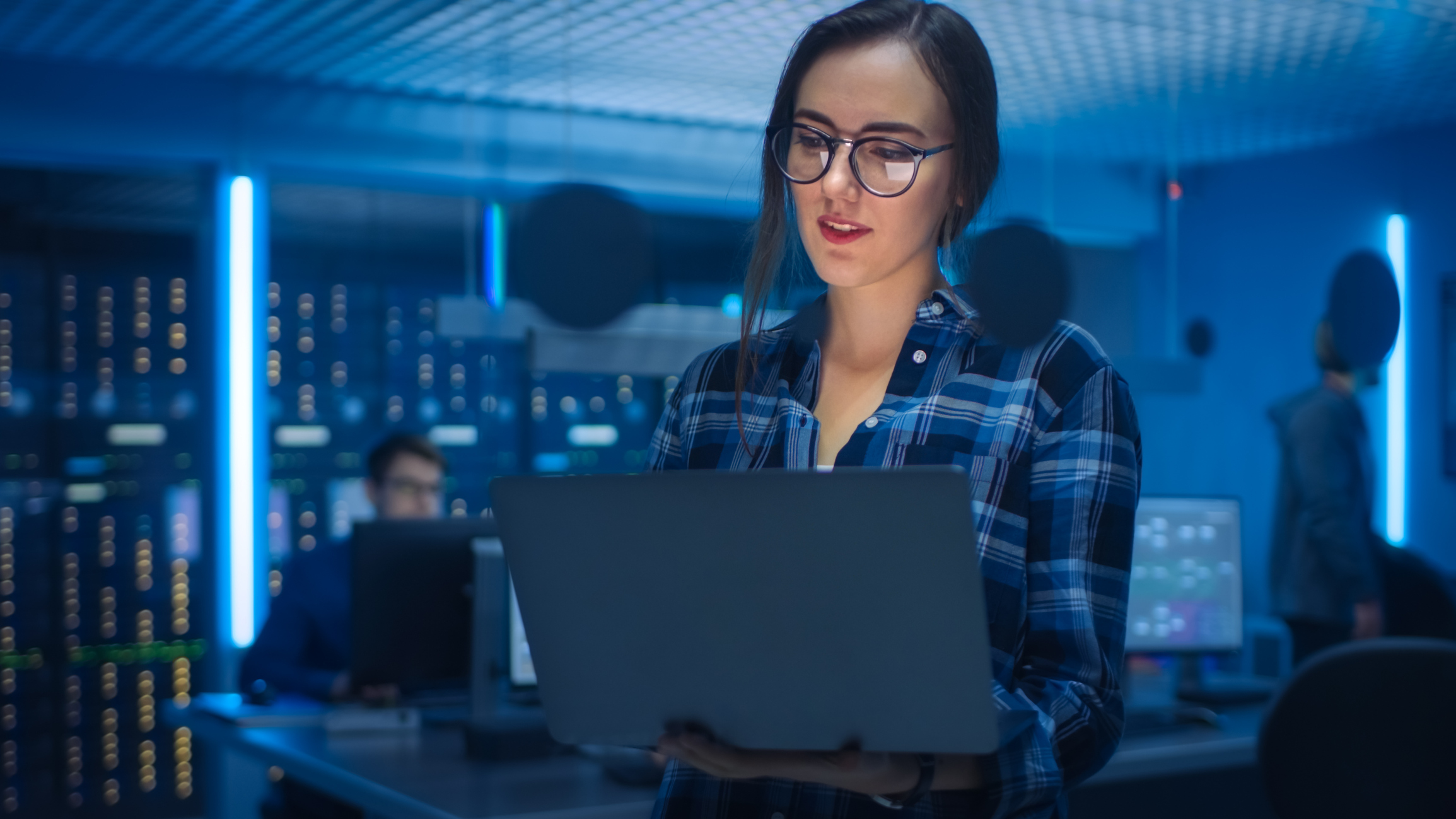 Women working in Tech looking at laptop in database room