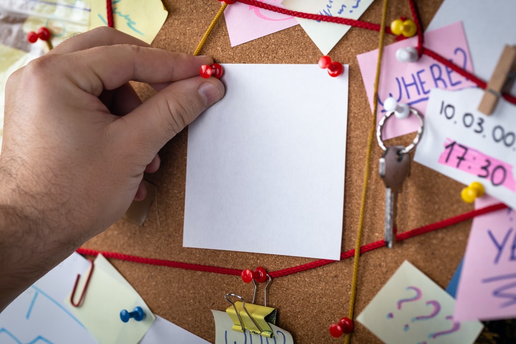 Closeup Blank Paper Being Placed on Pin Board