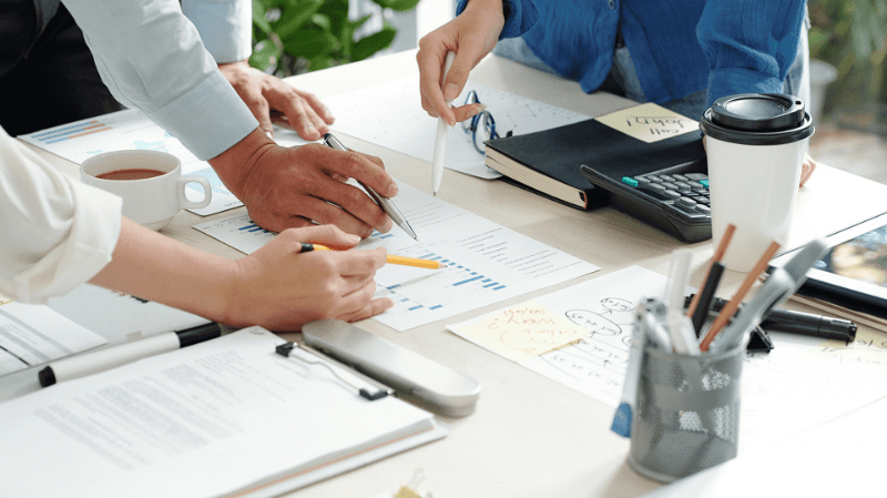 Professionals collaborating over charts and data during a business meeting.