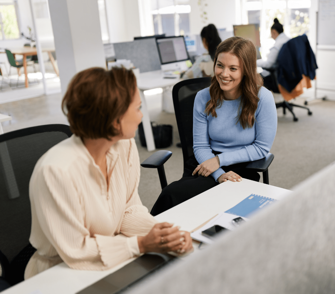 Founder and Director of ROUSSOS Recruitment, Anna Roussos discussing tasks for the day with a ROUSSOS team member in their spacious office