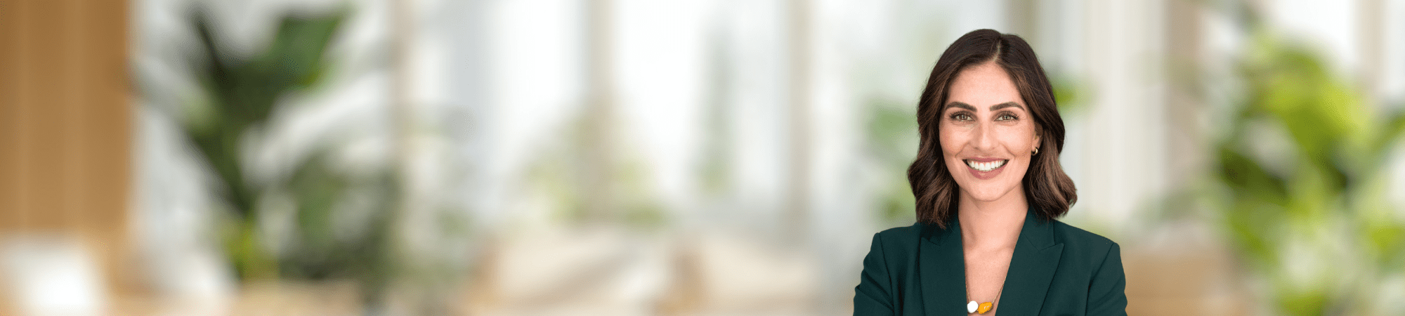 Smiling female professional wearing green jacket. 