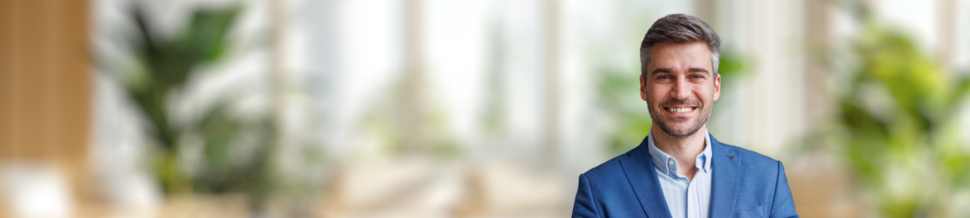 Smiling male professional wearing blue jacket. 