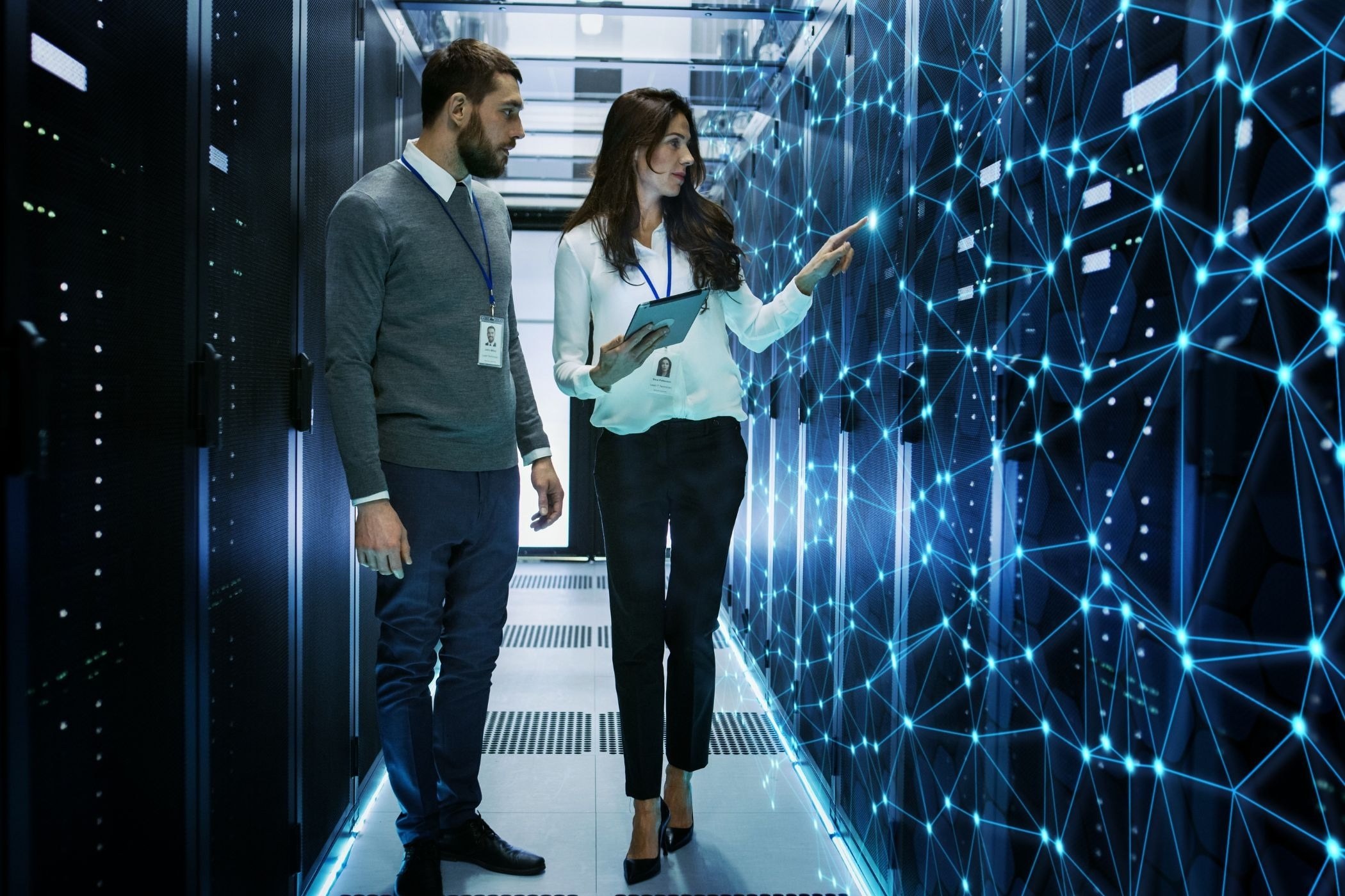 Two people working in a computer server room. 