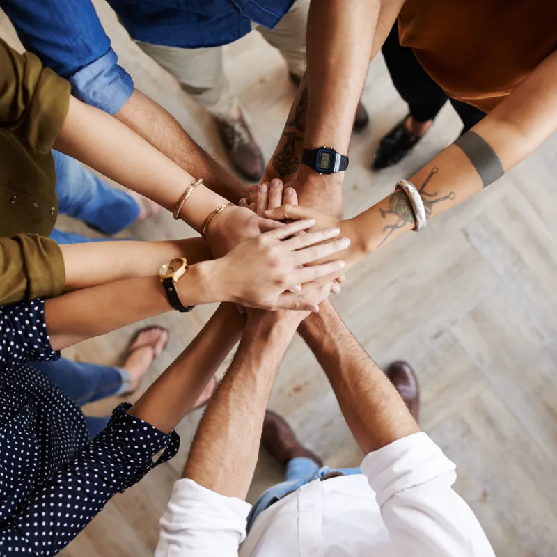 Hands stacked on top in a team high gathering