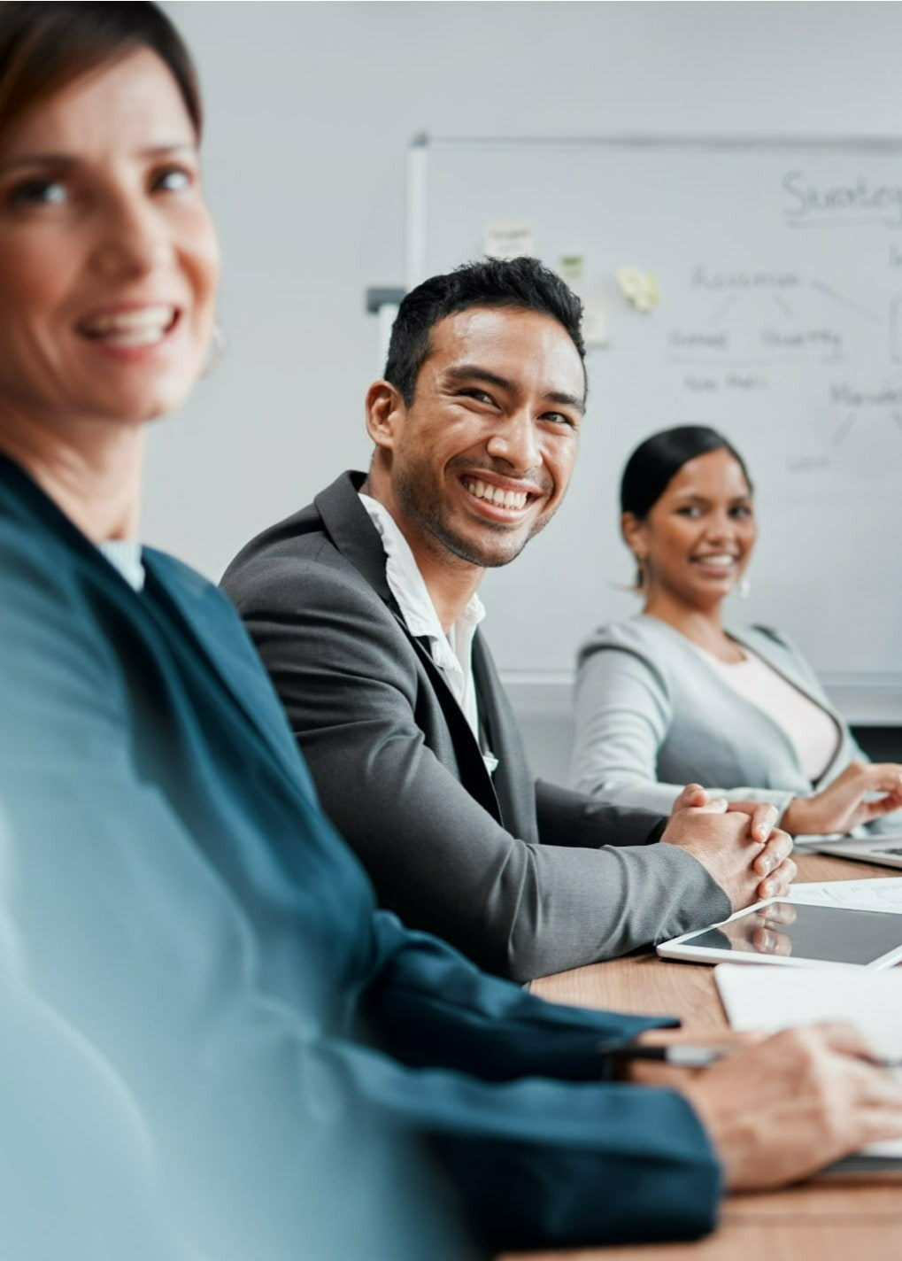 Three working professionals laughing during a meeting