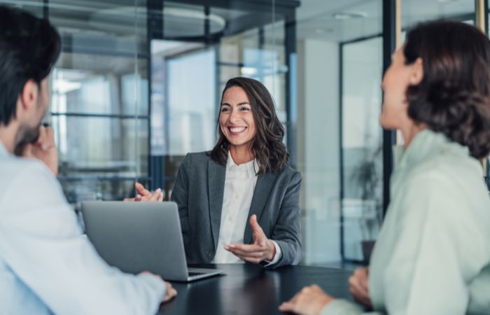 3 employees in boardroom meeting 