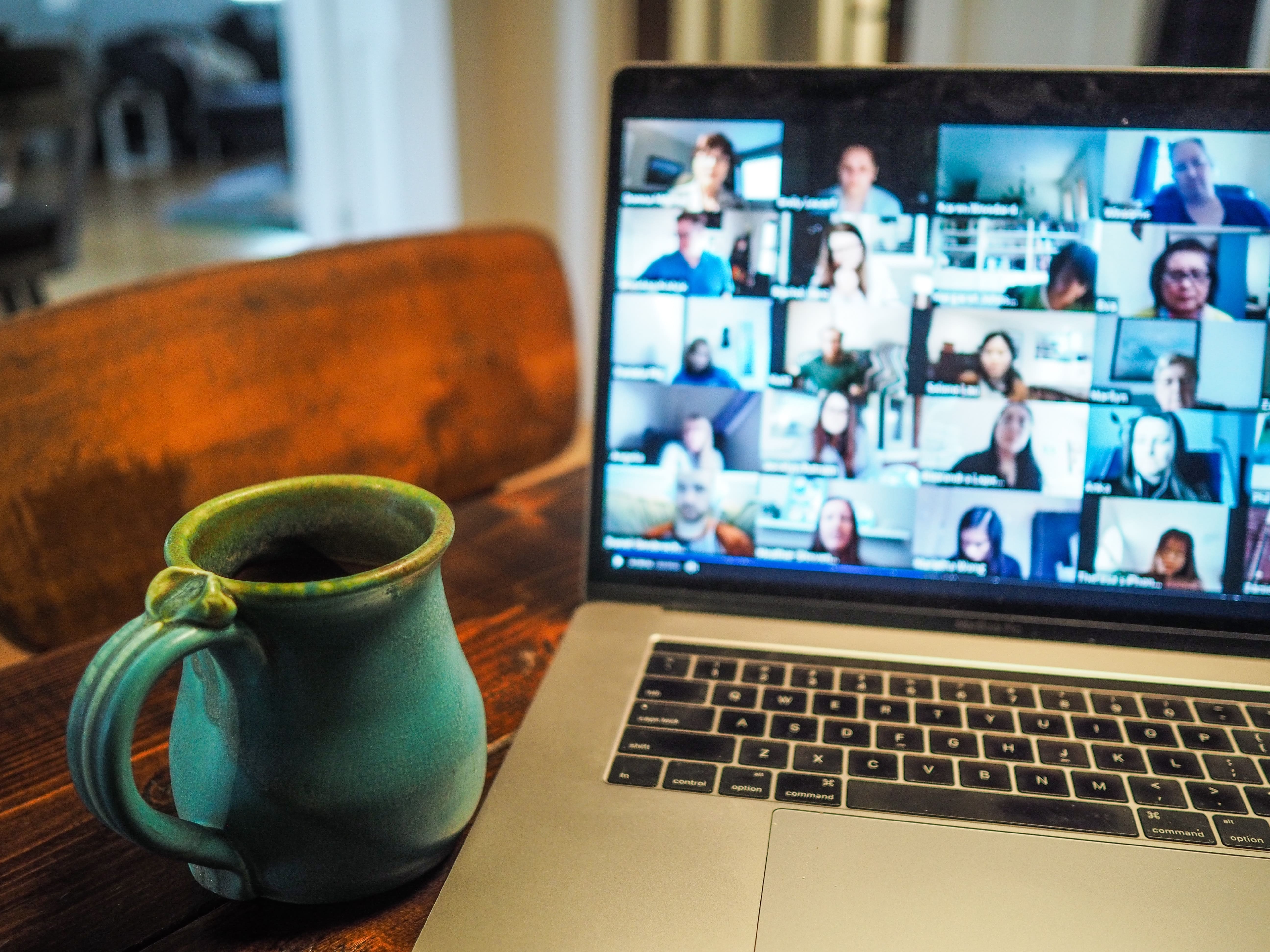 Cup of coffee and virtual meeting with work colleagues