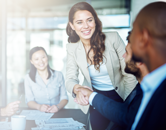 Person in a boardroom meeting smiling at people.
