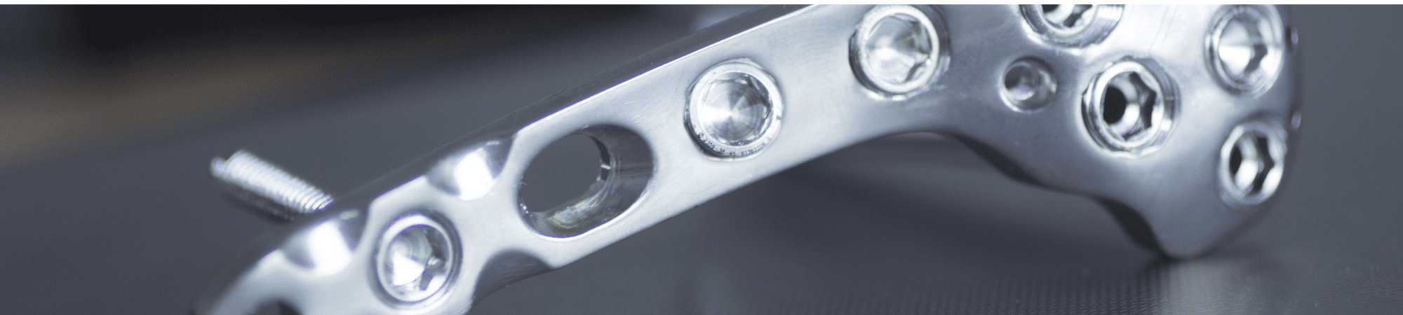 Close-up of orthopaedic plating on a black background, showcasing precision and advanced medical technology.