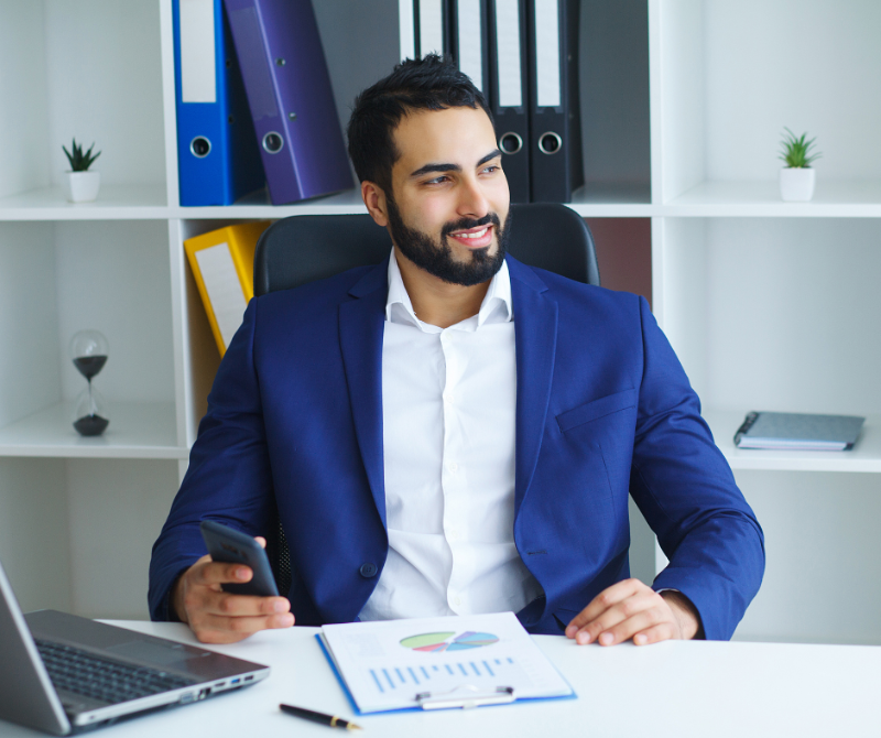 Confident professional seated at a desk with charts and a phone, symbolising career planning and strategic thinking.