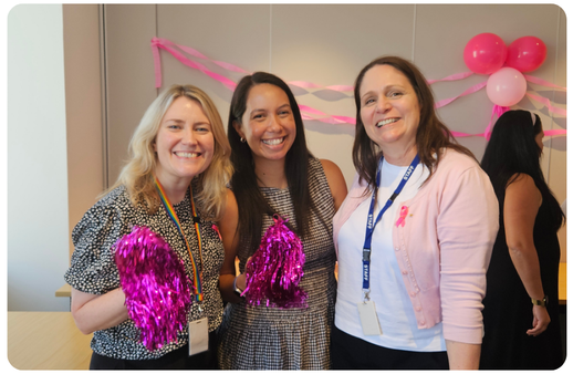 three women wearing pink smiling