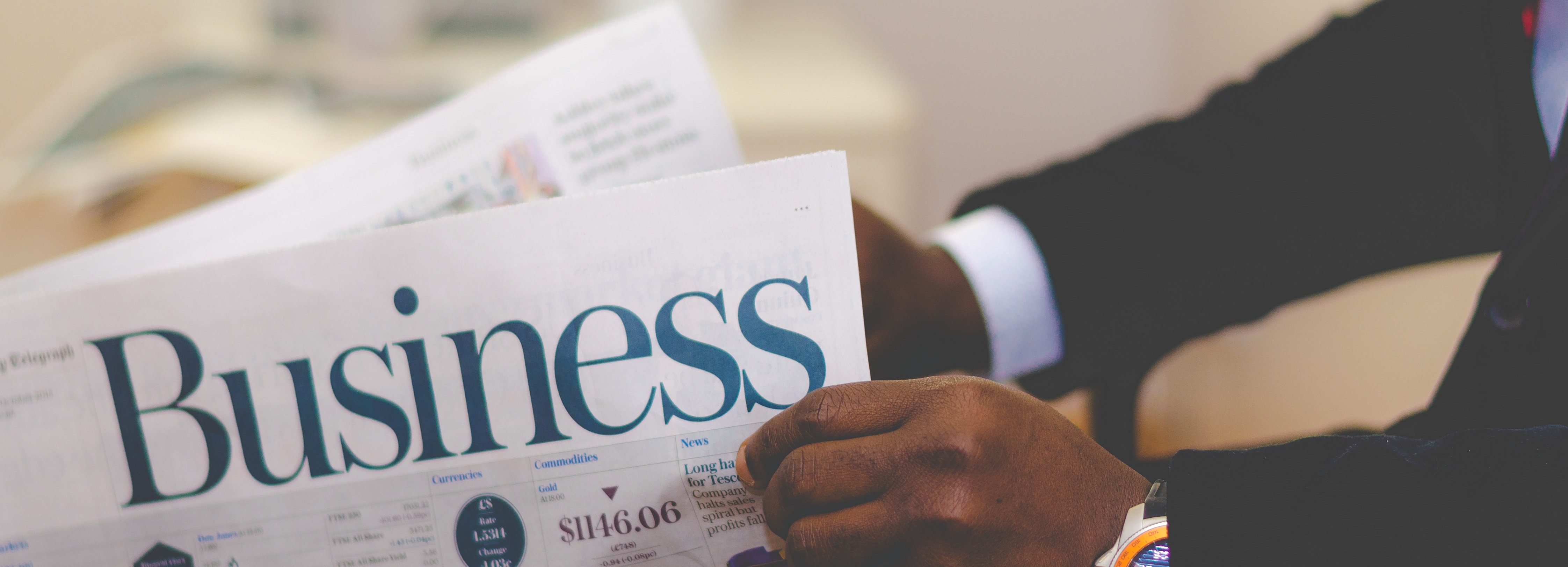 Office worker wearing a suit and reading Business Newpaper