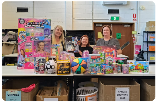 happy people behind a table of donated christmas presents