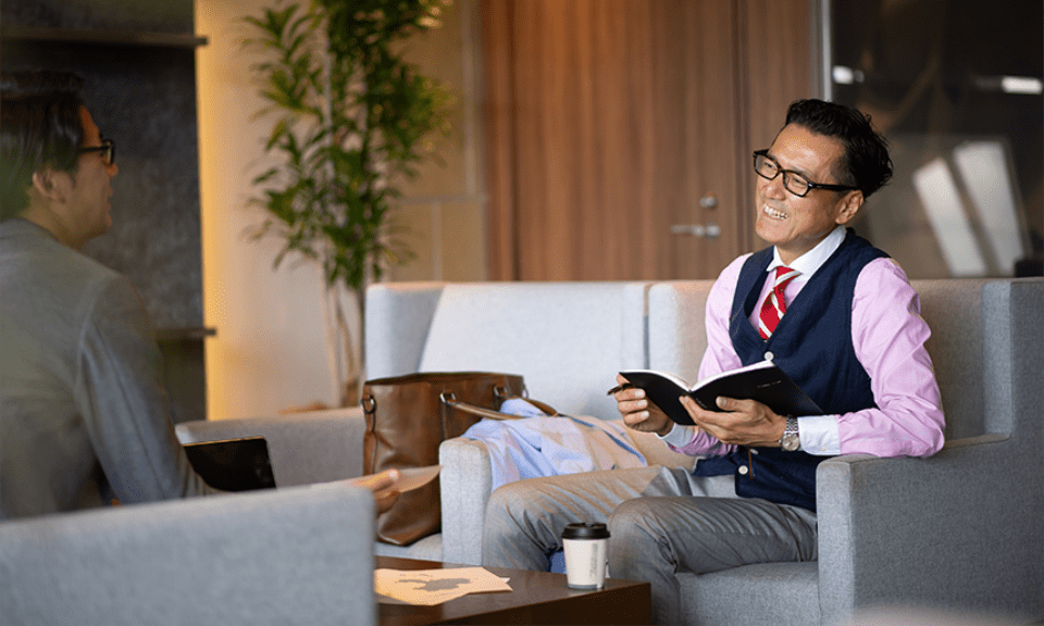 Japanese business people discussing while sitting down