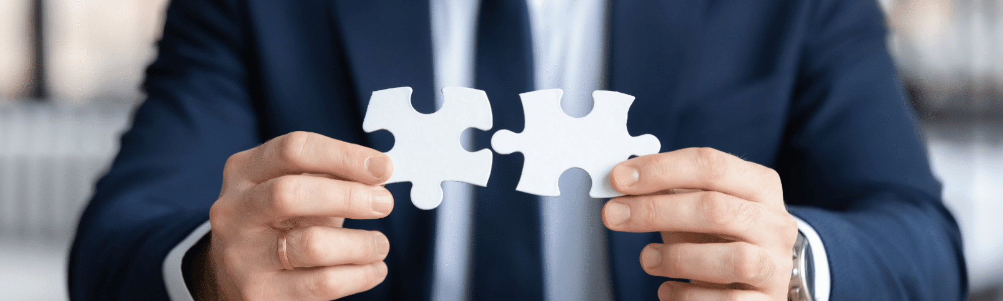 Business professional connecting two puzzle pieces, symbolising strategic hiring alignment.