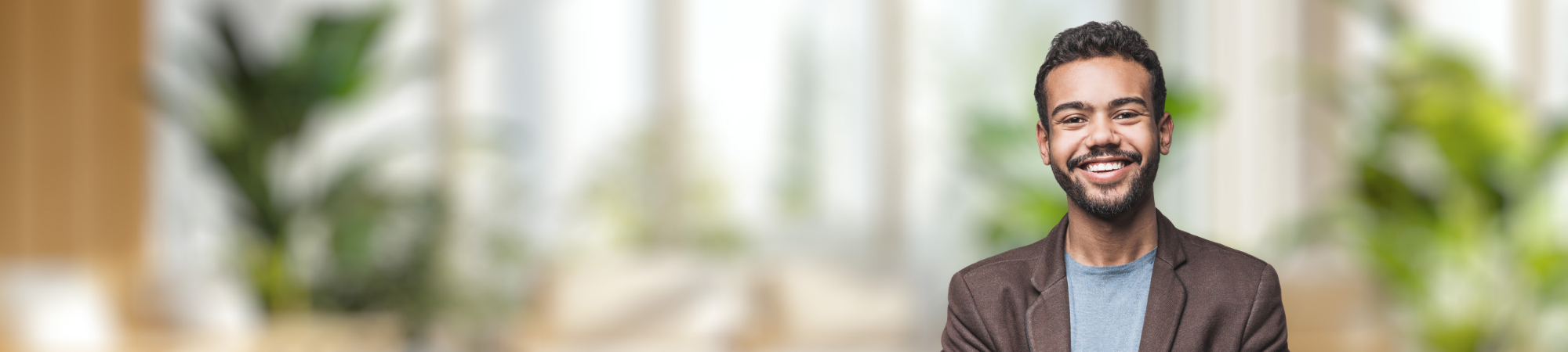 Smiling male professional in brown jacket.