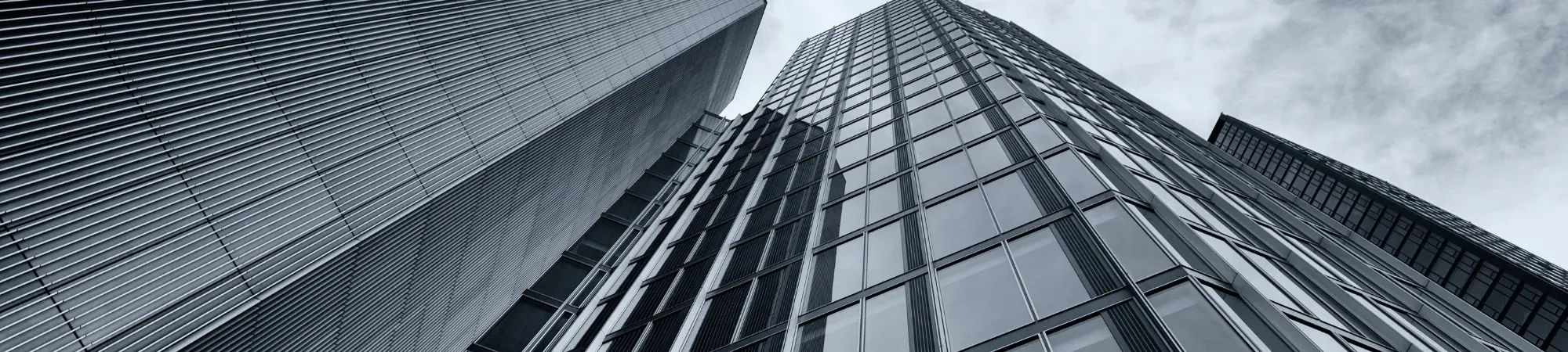 black and white image of a shiny office building looking up