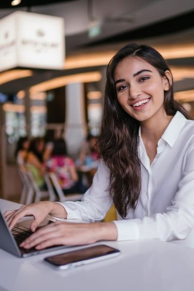 Young graduate student working on a laptop in a coworking space.. 