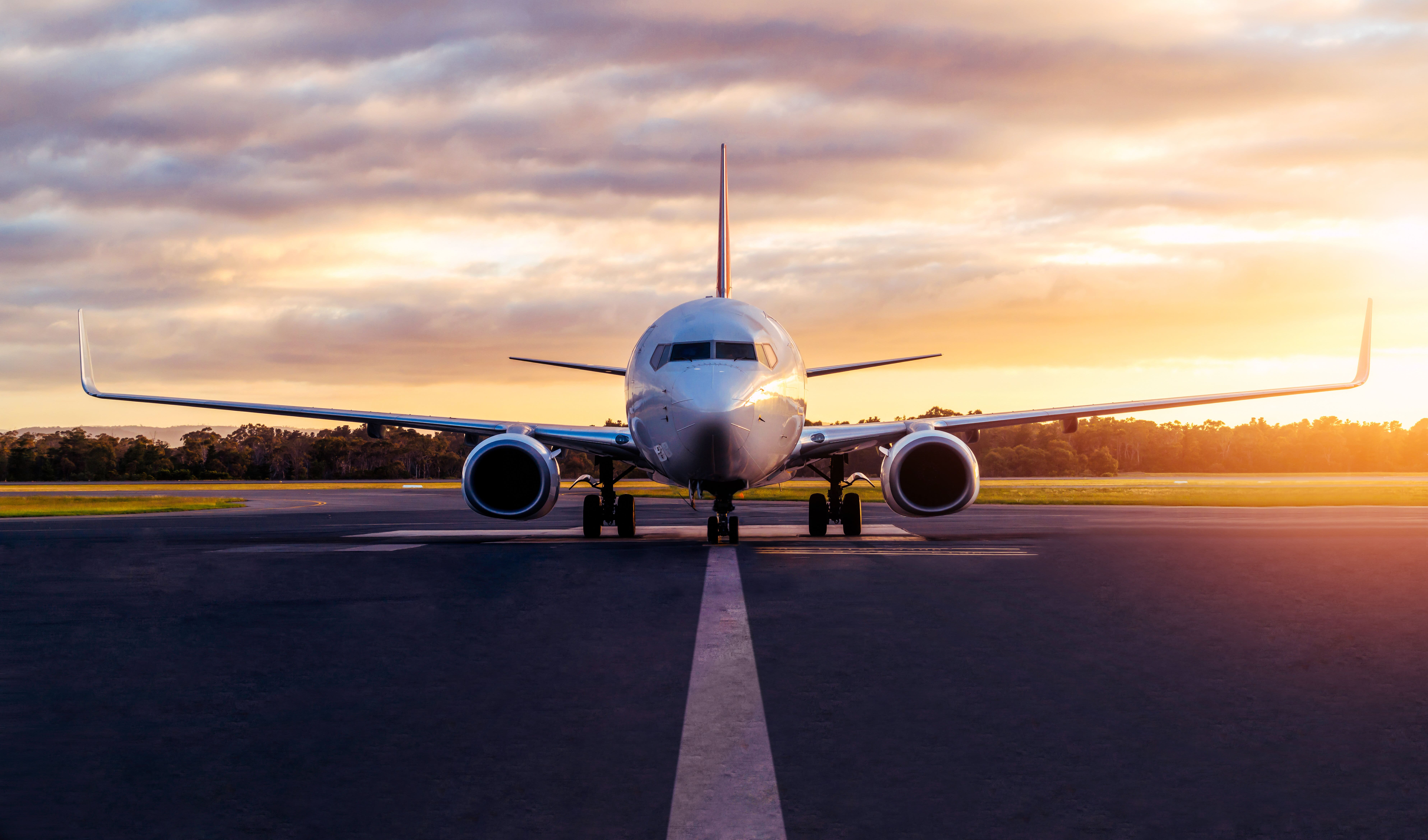 Commercial Airplane on runway while sunsets