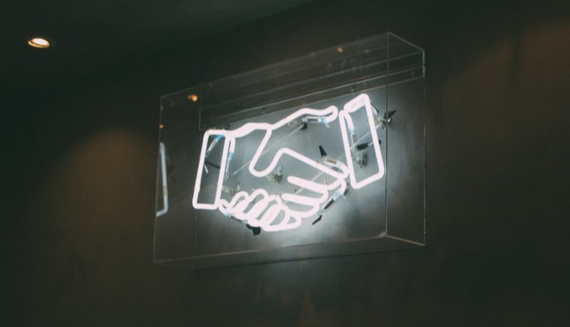 White Neon Sign Handshake for Building Trust