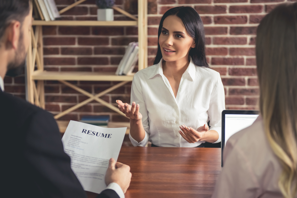 Beautiful female employee in suit is smiling during the job interview