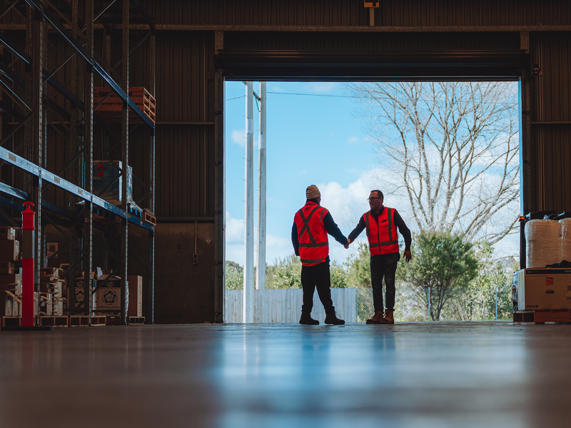 Two Employee shaking hands in warehouse