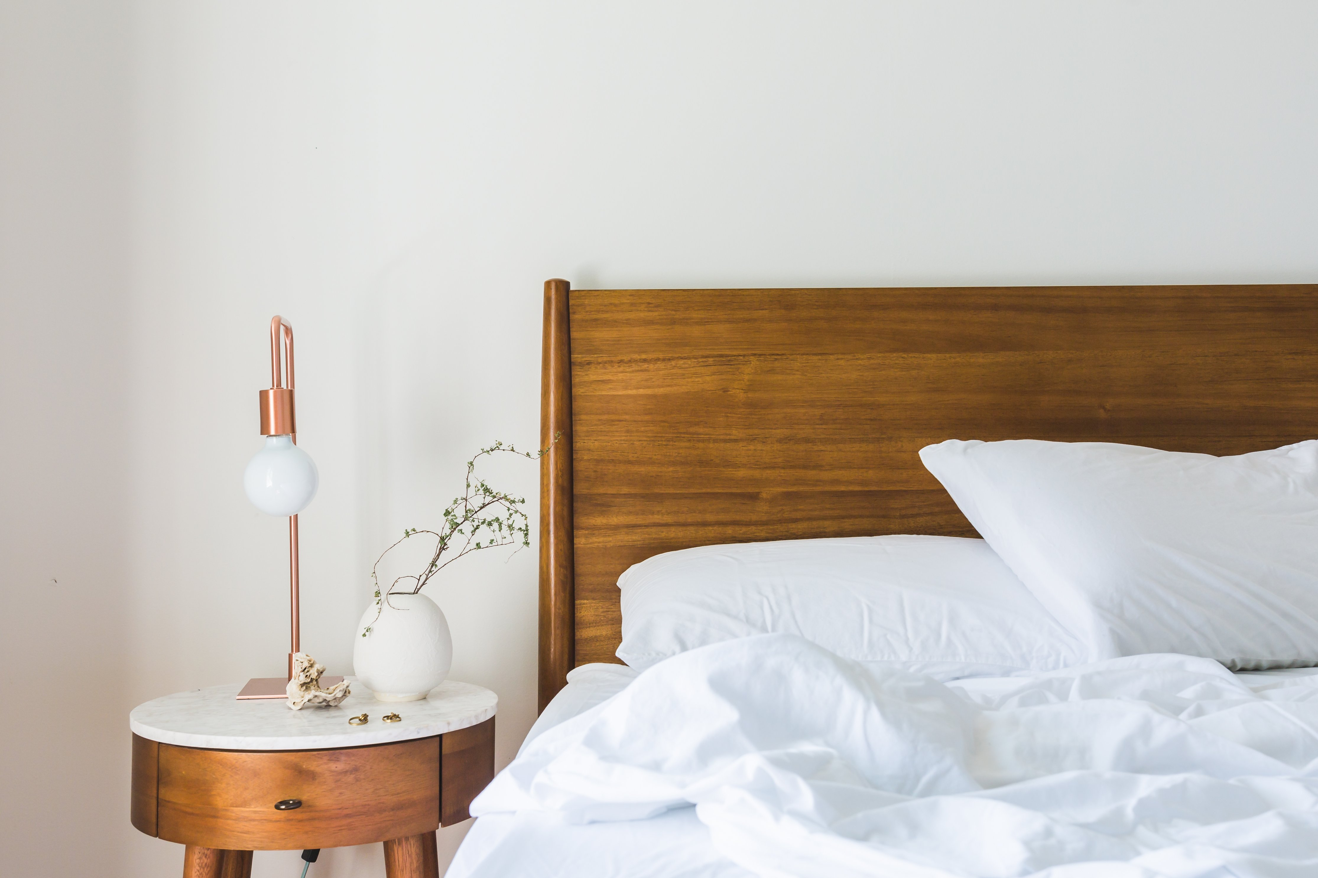 Canva   White Bedspread Beside Nightstand With White And Copper Table Lamp