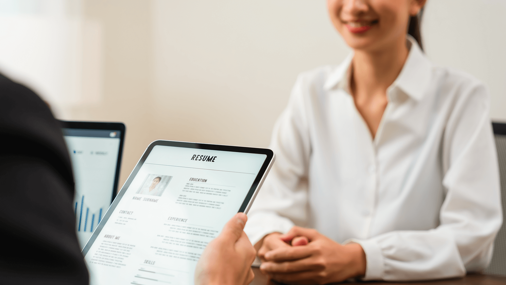 Job candidate presenting her digital resume on a tablet during a job interview.