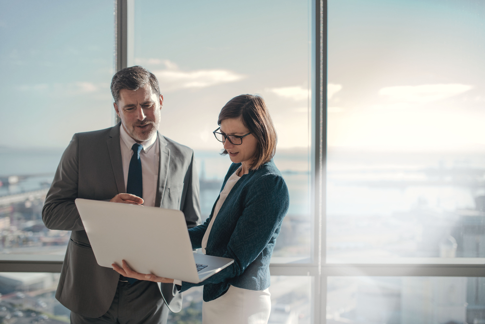 Business Man And Woman Reviewing Laptop